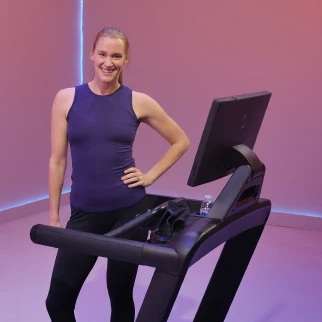 A coach leading a class on an Aviron treadmill